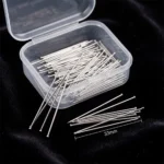 A clear plastic storage box containing fine, silver-toned headless straight pins designed for scarves and turbans, displayed against a black background