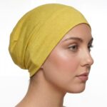 Flat lay of golden-yellow premium soft stretch knitted cotton under scarf cap by SCARF 'N' SHAWLS measuring 24.5 cm x 22 cm