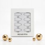 Pack of 8 snag-free hijab safety clips in [Colour Name] displayed in a white window box for scarf and clothing decoration.