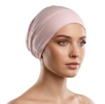 Side profile of a woman wearing a soft, stretchable light-pink inner hijab cap against a white background