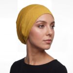 Flat lay of mustard-yellow premium soft stretch knitted cotton under scarf cap by SCARF 'N' SHAWLS measuring 24.5 cm x 22 cm