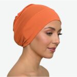 Flat lay of neon-orange premium soft stretch knitted cotton under scarf cap by SCARF 'N' SHAWLS measuring 24.5 cm x 22 cm