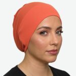 Flat lay of orange premium soft stretch knitted cotton under scarf cap by SCARF 'N' SHAWLS measuring 24.5 cm x 22 cm