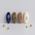 A set of four oval solid-colour safety pin buckles for hijab and scarf styling, featuring a hidden pin design in Earthy Tones