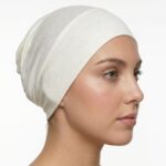 Side profile of a woman wearing a soft, stretchable sea-shell inner hijab cap against a white background.
