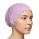 Side profile of a woman wearing a soft, stretchable sherbet inner hijab cap against a white background