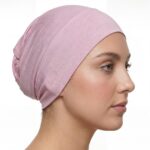 Side profile of a woman wearing a soft, stretchable sherbet-candy inner hijab cap against a white background