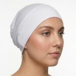 Side profile of a woman wearing a soft, stretchable snow inner hijab cap against a white background.