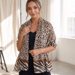 Model in black top wearing a tan and chocolate leopard print scarf with a zebra stripe border.