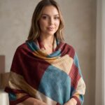 Woman wearing a multi-color block scarf featuring teal, burgundy, and tan geometric patterns.